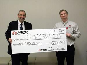 Kevin Leonard of Huronia Alarms presents cheque